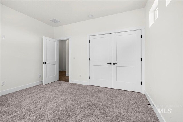 unfurnished bedroom featuring a closet and carpet flooring