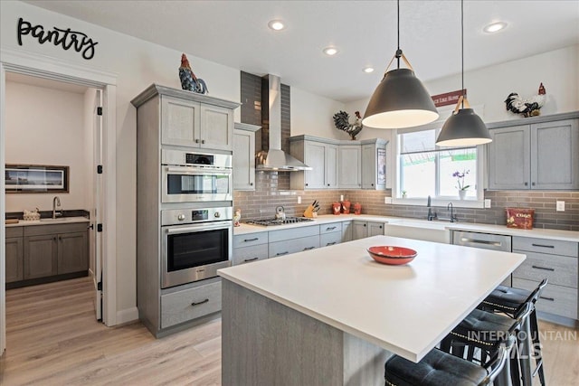 20150 Silver Spur Dr, Wilder, ID 83676 - kitchen with wall chimney exhaust hood, gray cabinets, a sink, appliances with stainless steel finishes, and a kitchen bar