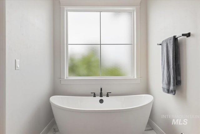 20150 Silver Spur Dr, Wilder, ID 83676 - full bath featuring baseboards, marble look tile flooring, plenty of natural light, and a freestanding bath