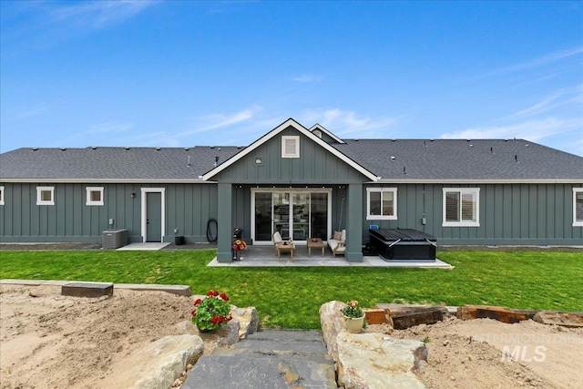 20150 Silver Spur Dr, Wilder, ID 83676 - rear view of house with a hot tub, board and batten siding, a patio, and a lawn