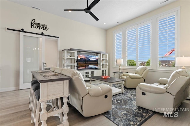 20150 Silver Spur Dr, Wilder, ID 83676 - living area featuring a barn door, a ceiling fan, wood finished floors, and baseboards