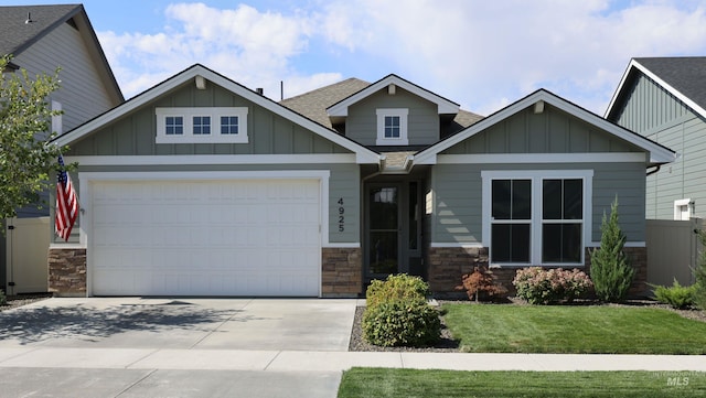 craftsman inspired home featuring a garage, stone siding, driveway, and board and batten siding