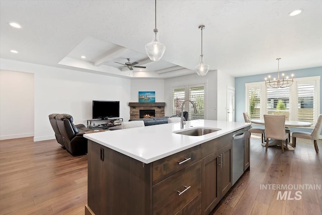 kitchen featuring dark wood-style floors, a sink, light countertops, dark brown cabinets, and stainless steel dishwasher