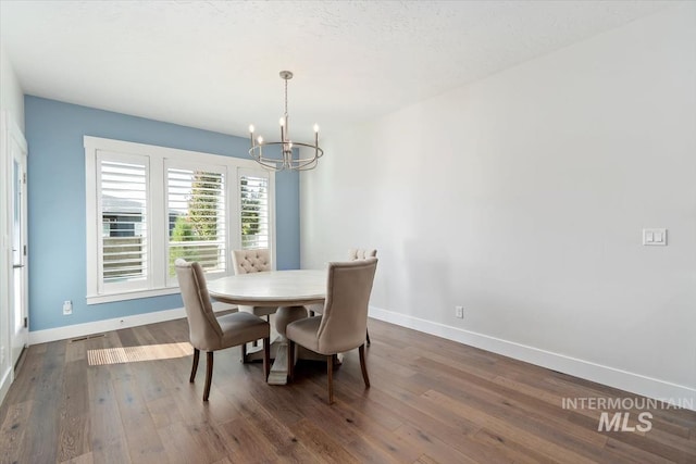 dining room featuring a chandelier, dark wood finished floors, visible vents, and baseboards