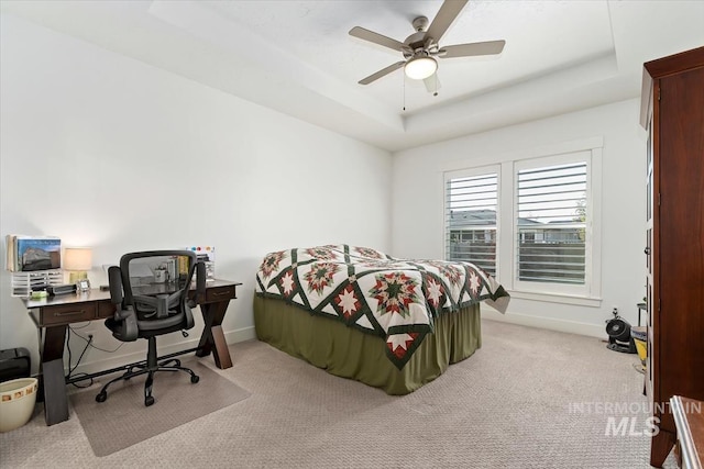 bedroom featuring a ceiling fan, baseboards, a raised ceiling, and carpet flooring