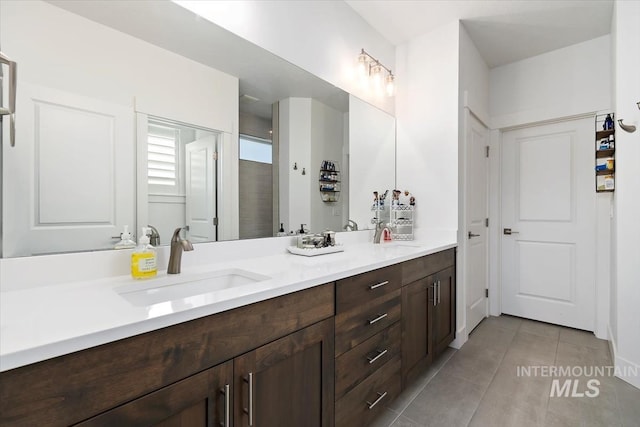 bathroom with double vanity, tile patterned flooring, and a sink