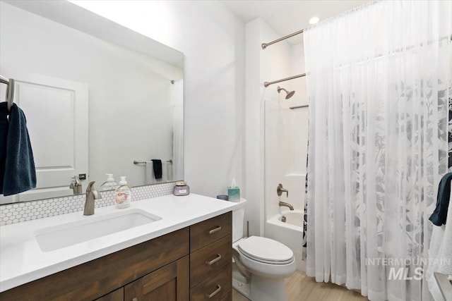 full bath featuring toilet, shower / bathtub combination with curtain, and vanity