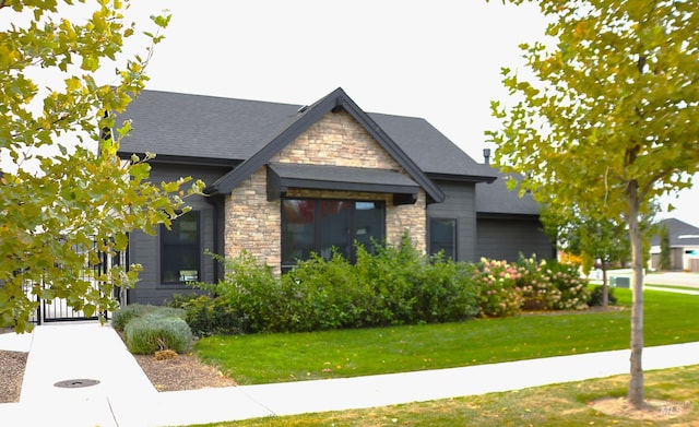 craftsman-style house with stone siding and a front lawn