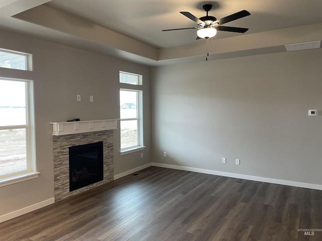 unfurnished living room featuring visible vents, dark wood finished floors, baseboards, and a healthy amount of sunlight