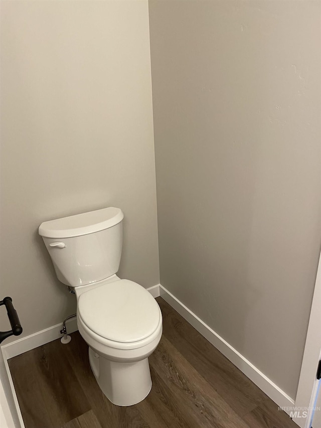 bathroom with baseboards, toilet, and wood finished floors