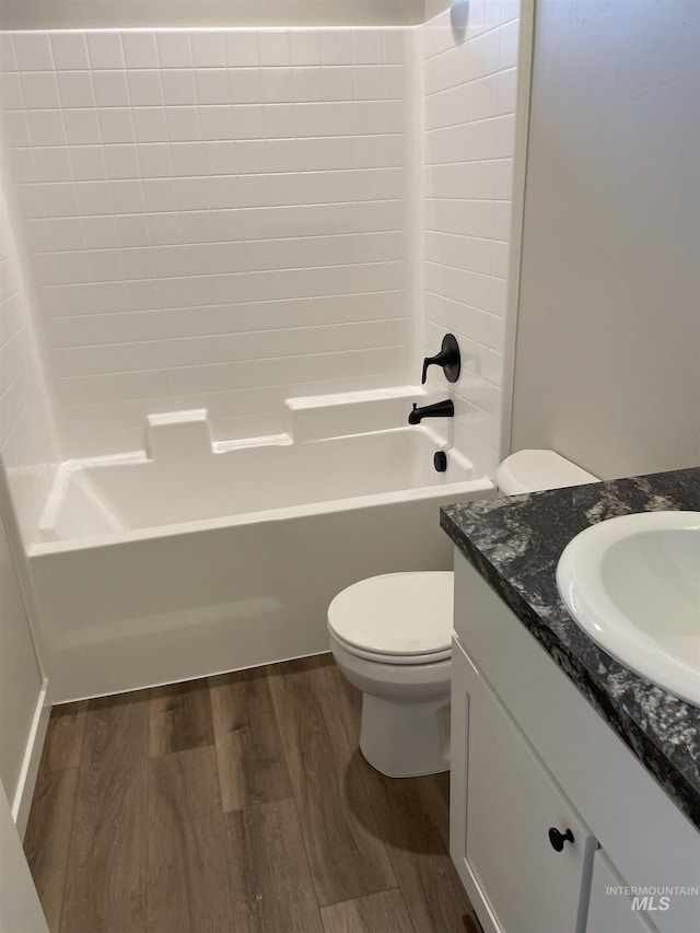 full bathroom featuring toilet, bathing tub / shower combination, wood finished floors, and vanity