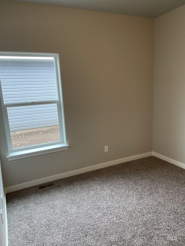 unfurnished room with carpet flooring, baseboards, and visible vents