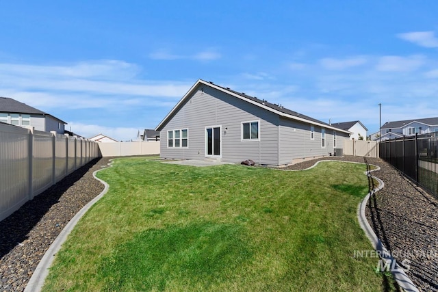 rear view of property with a yard and central AC unit