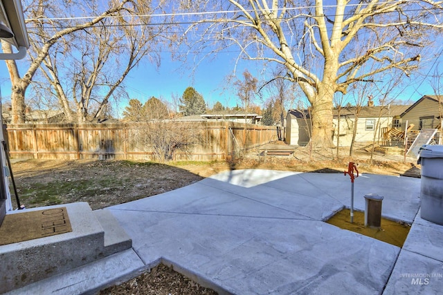 view of yard featuring a patio area, a fenced backyard, and an outdoor structure