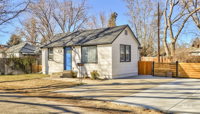 view of front of home with a shingled roof and fence