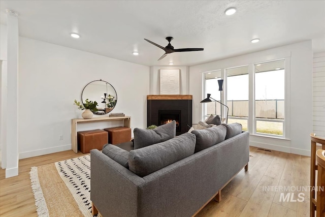 4628 N Camp Creek Ave, Meridian, ID 83646 - living area featuring baseboards, a ceiling fan, a lit fireplace, and light wood finished floors