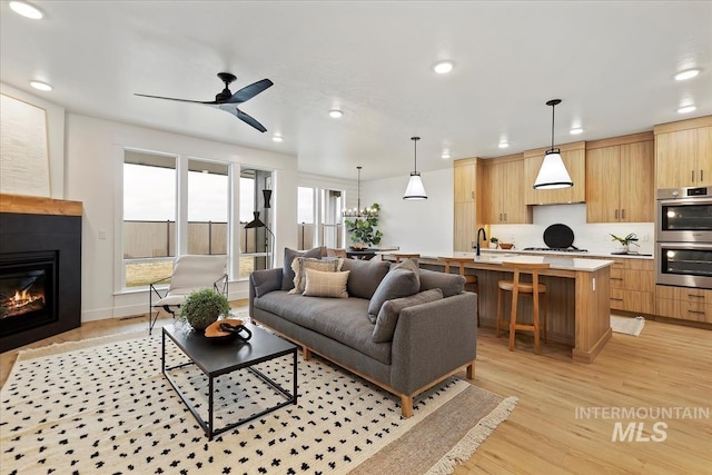 4628 N Camp Creek Ave, Meridian, ID 83646 - living area with a glass covered fireplace, ceiling fan, recessed lighting, and light wood-style flooring