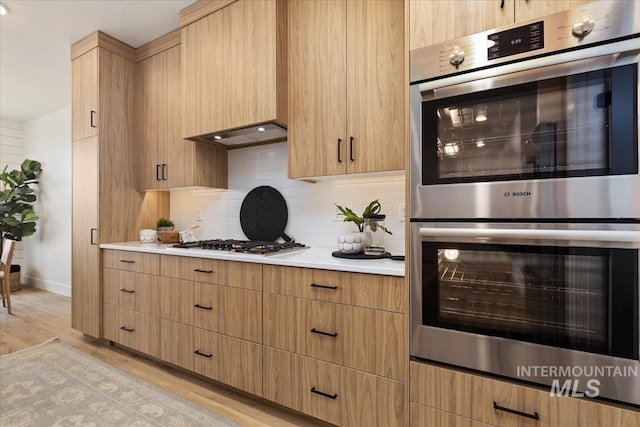 4628 N Camp Creek Ave, Meridian, ID 83646 - kitchen featuring light brown cabinets, light wood-style floors, appliances with stainless steel finishes, light countertops, and backsplash