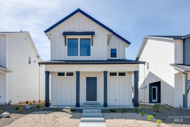 modern farmhouse style home with a standing seam roof, metal roof, board and batten siding, and covered porch