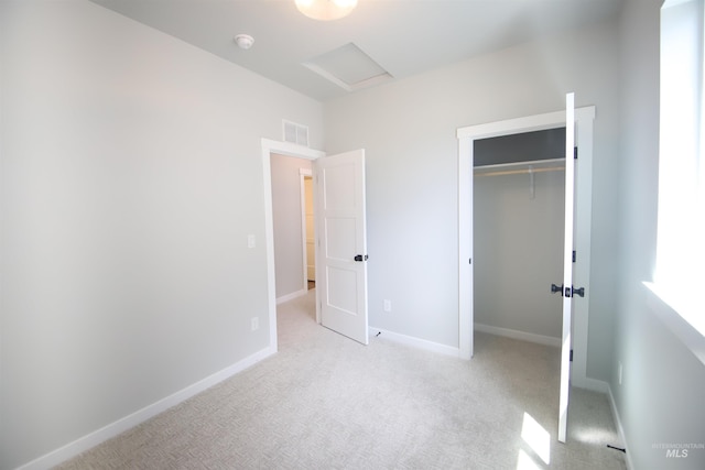 unfurnished bedroom featuring light colored carpet, a closet, visible vents, and baseboards