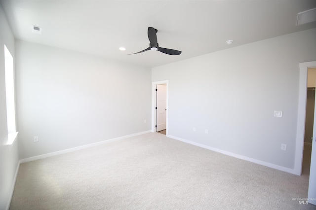 spare room featuring visible vents, ceiling fan, light carpet, and baseboards