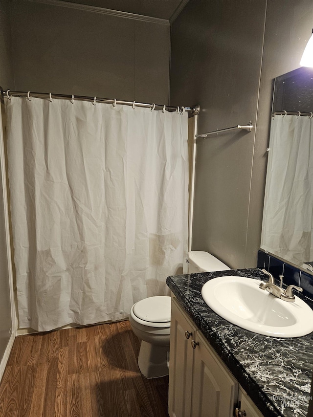 bathroom with hardwood / wood-style floors, vanity, toilet, and ornamental molding