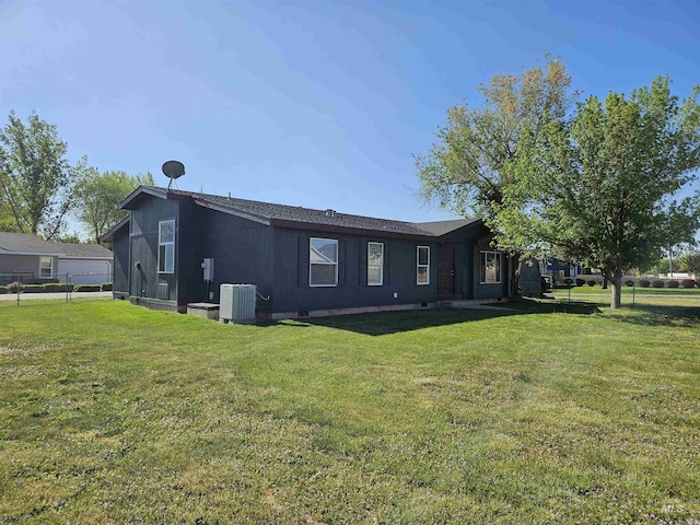 back of house featuring a lawn and cooling unit