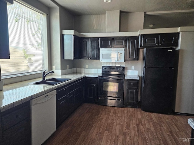 kitchen featuring dark hardwood / wood-style flooring, decorative backsplash, sink, and black appliances