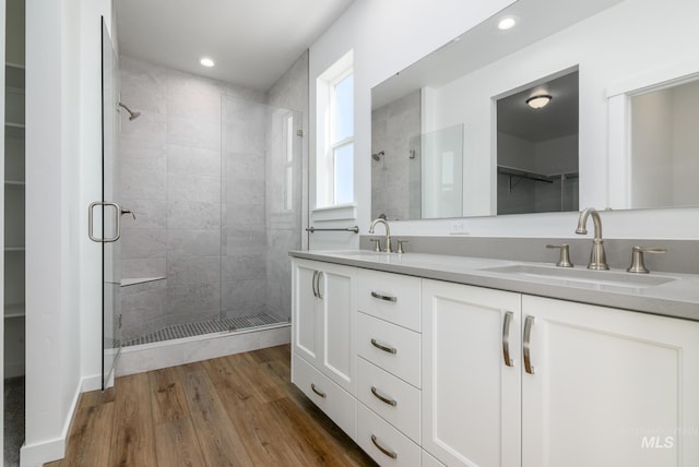 bathroom with hardwood / wood-style floors, vanity, and walk in shower