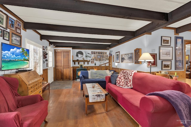 living room featuring beam ceiling, wooden walls, and hardwood / wood-style flooring