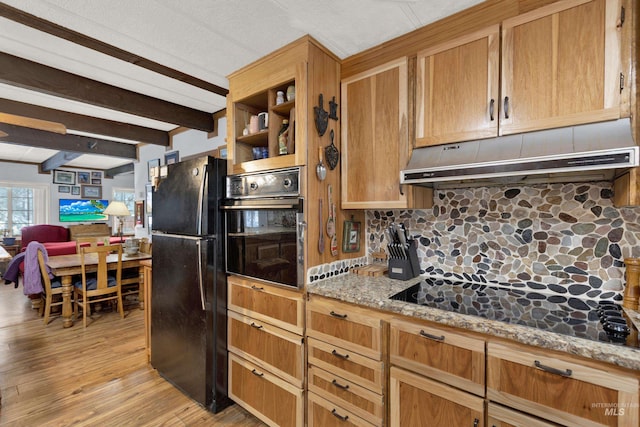 kitchen with light wood-type flooring, tasteful backsplash, light stone counters, black appliances, and beam ceiling