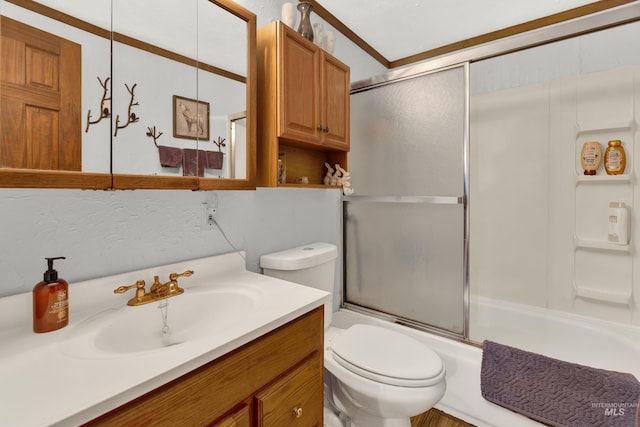 full bathroom featuring crown molding, toilet, vanity, and combined bath / shower with glass door