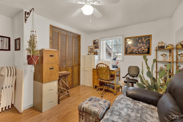 living area with light hardwood / wood-style flooring and ceiling fan