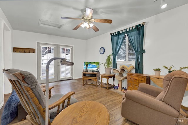 living area with ceiling fan and light hardwood / wood-style floors