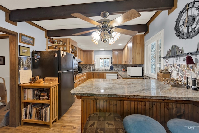 kitchen featuring tasteful backsplash, kitchen peninsula, beamed ceiling, and white appliances