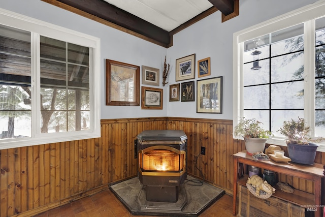 details featuring a wood stove, beamed ceiling, and hardwood / wood-style flooring