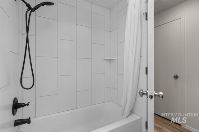 bathroom featuring shower / bathtub combination with curtain and wood finished floors
