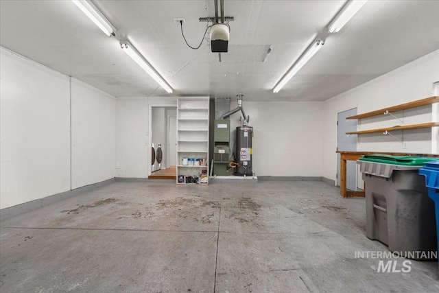 garage featuring baseboards, washing machine and dryer, a garage door opener, and water heater