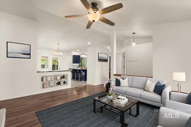 living area with wood finished floors, recessed lighting, a textured ceiling, a ceiling fan, and vaulted ceiling