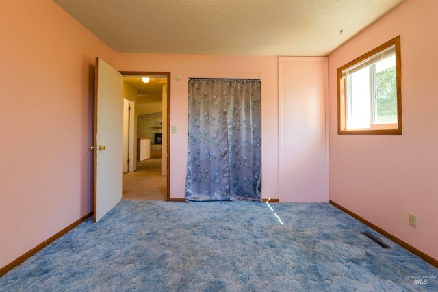 unfurnished bedroom with visible vents, baseboards, a textured ceiling, and carpet