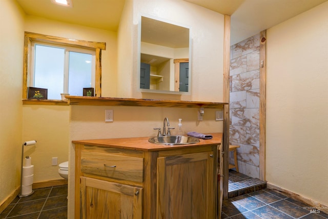 bathroom featuring vanity, baseboards, a shower stall, tile patterned floors, and toilet