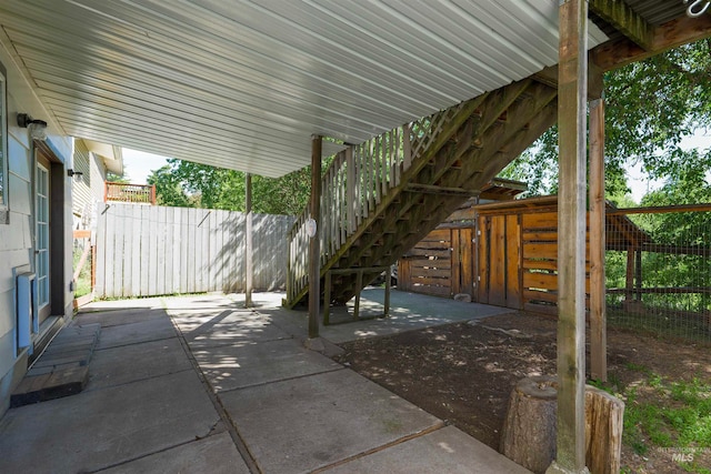 view of patio with stairway and fence