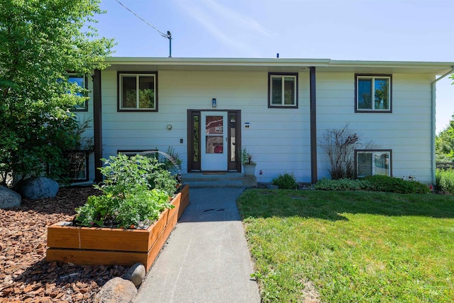 bi-level home with a garden and a front lawn