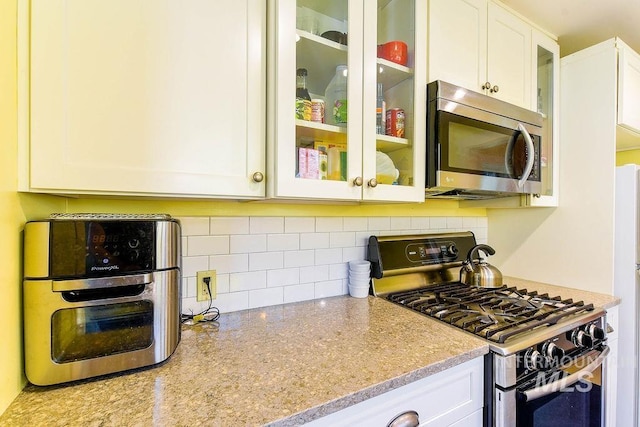 512 N Lincoln St, Moscow, ID 83843 - kitchen with white cabinets, tasteful backsplash, stainless steel appliances, and glass insert cabinets
