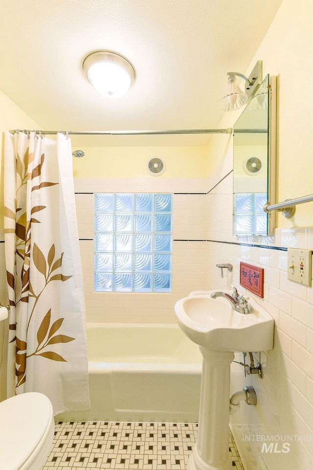 512 N Lincoln St, Moscow, ID 83843 - full bath featuring tile walls, toilet, and shower / bathtub combination with curtain