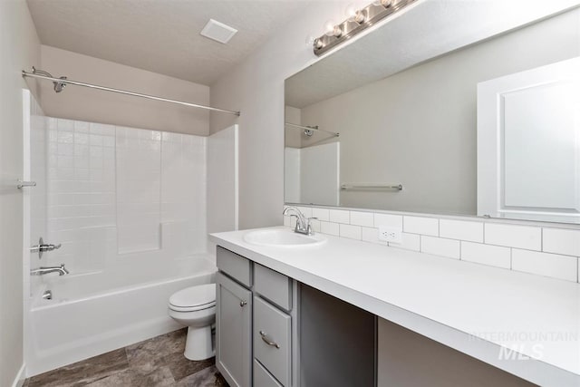 full bathroom with shower / bathing tub combination, vanity, tasteful backsplash, and toilet