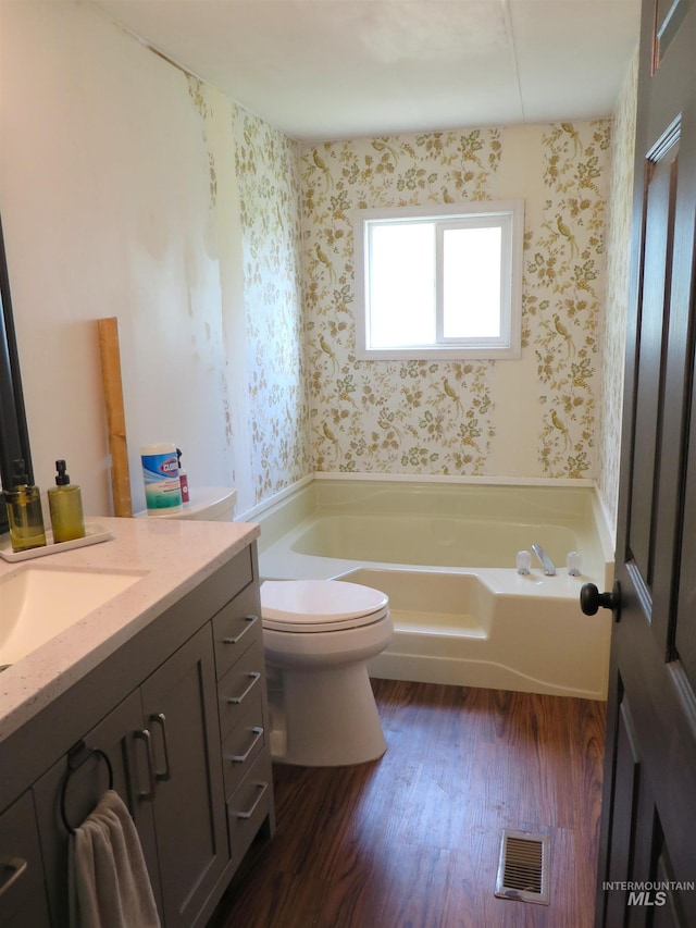 937 Indianhead Rd, Weiser, ID 83672 - full bath with wallpapered walls, a bath, toilet, wood finished floors, and vanity