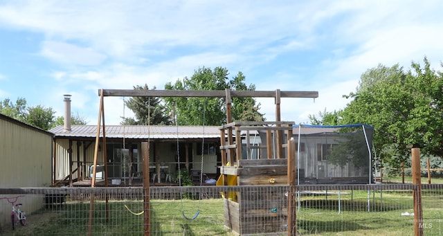 937 Indianhead Rd, Weiser, ID 83672 - rear view of property featuring a trampoline, metal roof, and a playground