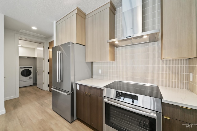 4340 E Haystack St Unit 210, Boise, ID 83716 - kitchen featuring wall chimney range hood, range, high end fridge, washer / dryer, and light countertops