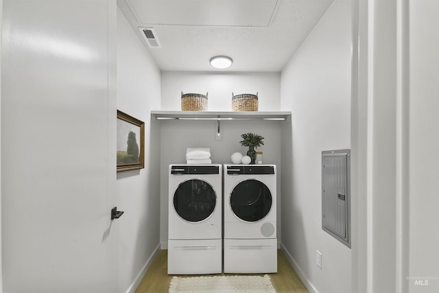 4340 E Haystack St Unit 210, Boise, ID 83716 - washroom featuring washer and clothes dryer, attic access, electric panel, and light wood-type flooring